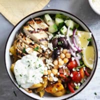 Greek Chicken Bowls with greek roasted potatoes, grilled chicken, and homemade tzatziki sauce.