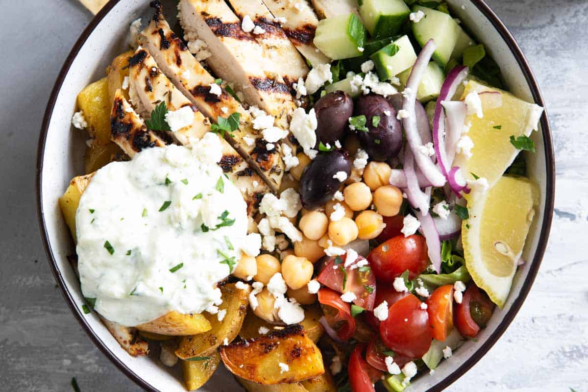 Greek Chicken Bowls topped with homemade tzatziki sauce.