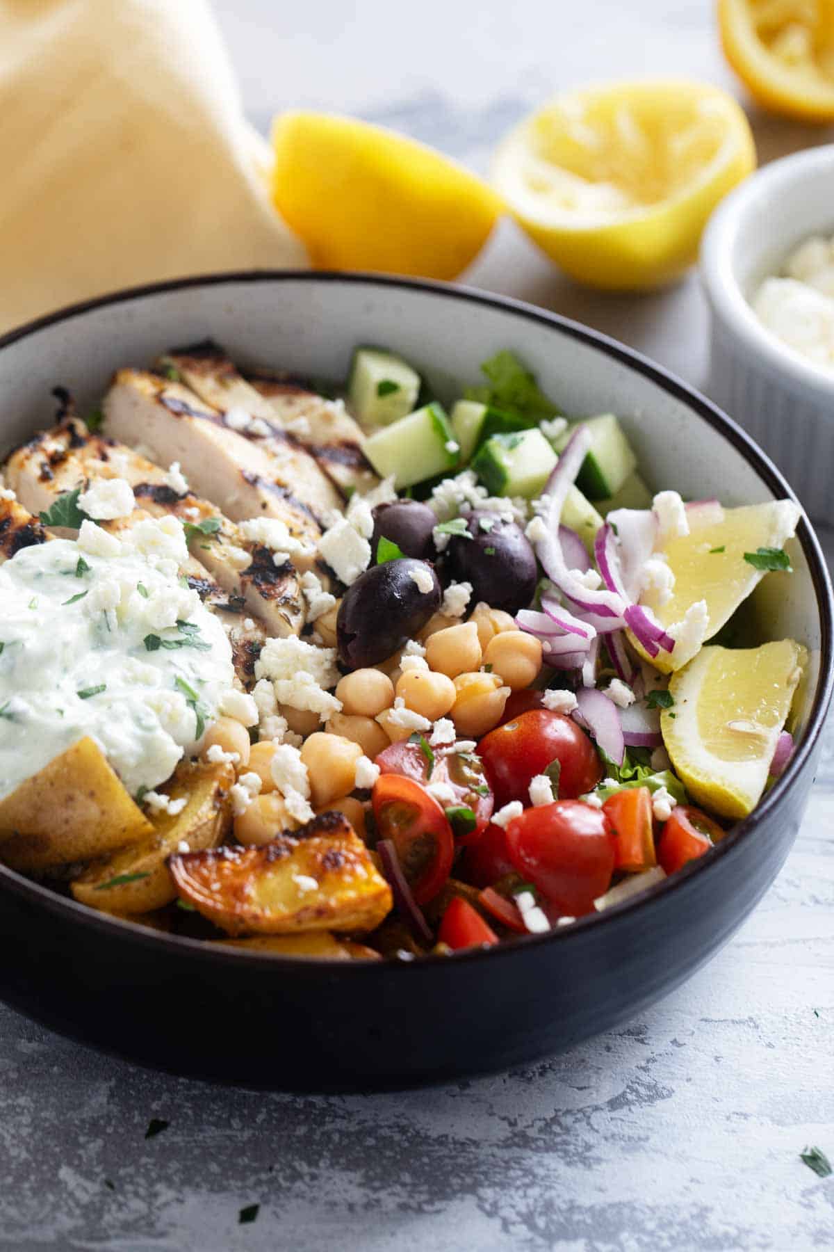 Greek Chicken Bowls with Greek roasted potatoes, grilled chicken, and lots of vegetables.