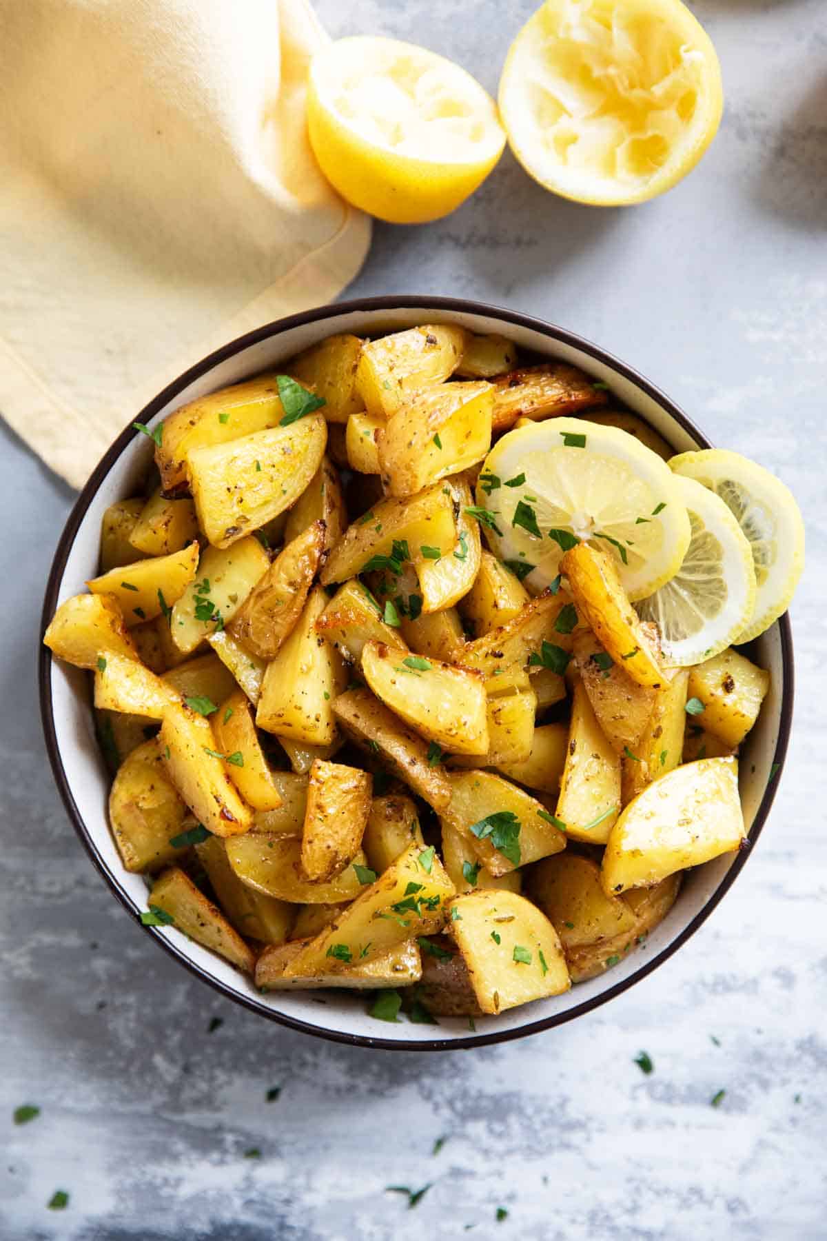 Greek Lemon Potatoes cut into wedges in a bowl.
