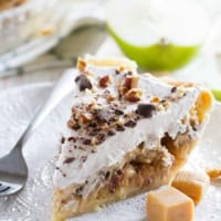 Slice of Taffy Apple Cheesecake Pie on a plate with pieces of caramel.