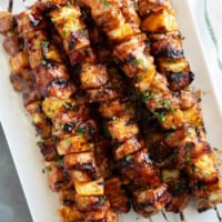 BBQ Pork Kabobs with Pineapple stacked on a plate.