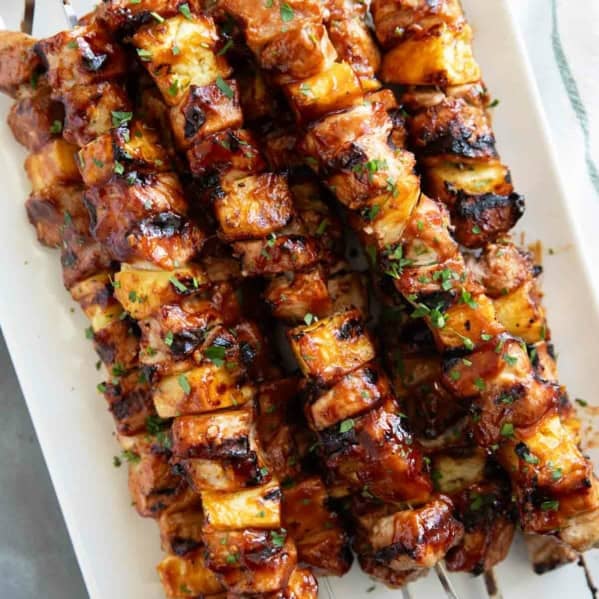 BBQ Pork Kabobs with Pineapple stacked on a plate.
