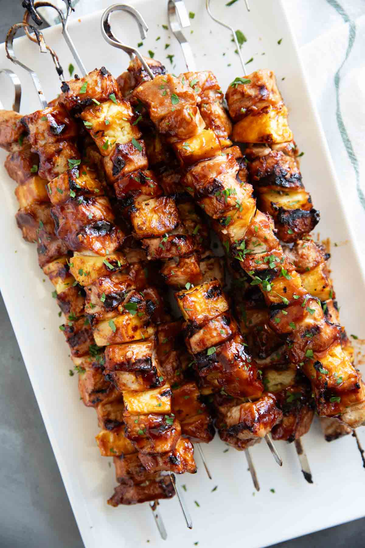 BBQ Pork Kabobs with Pineapple stacked on a plate.