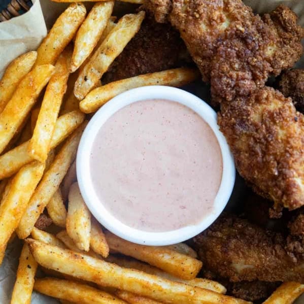 Basket filled with fries, chicken tenders, and Comeback Sauce.