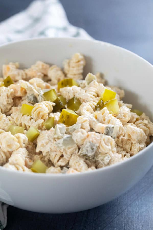 Serving bowl filled with Dill Pickle Pasta Salad topped with chopped pickles.