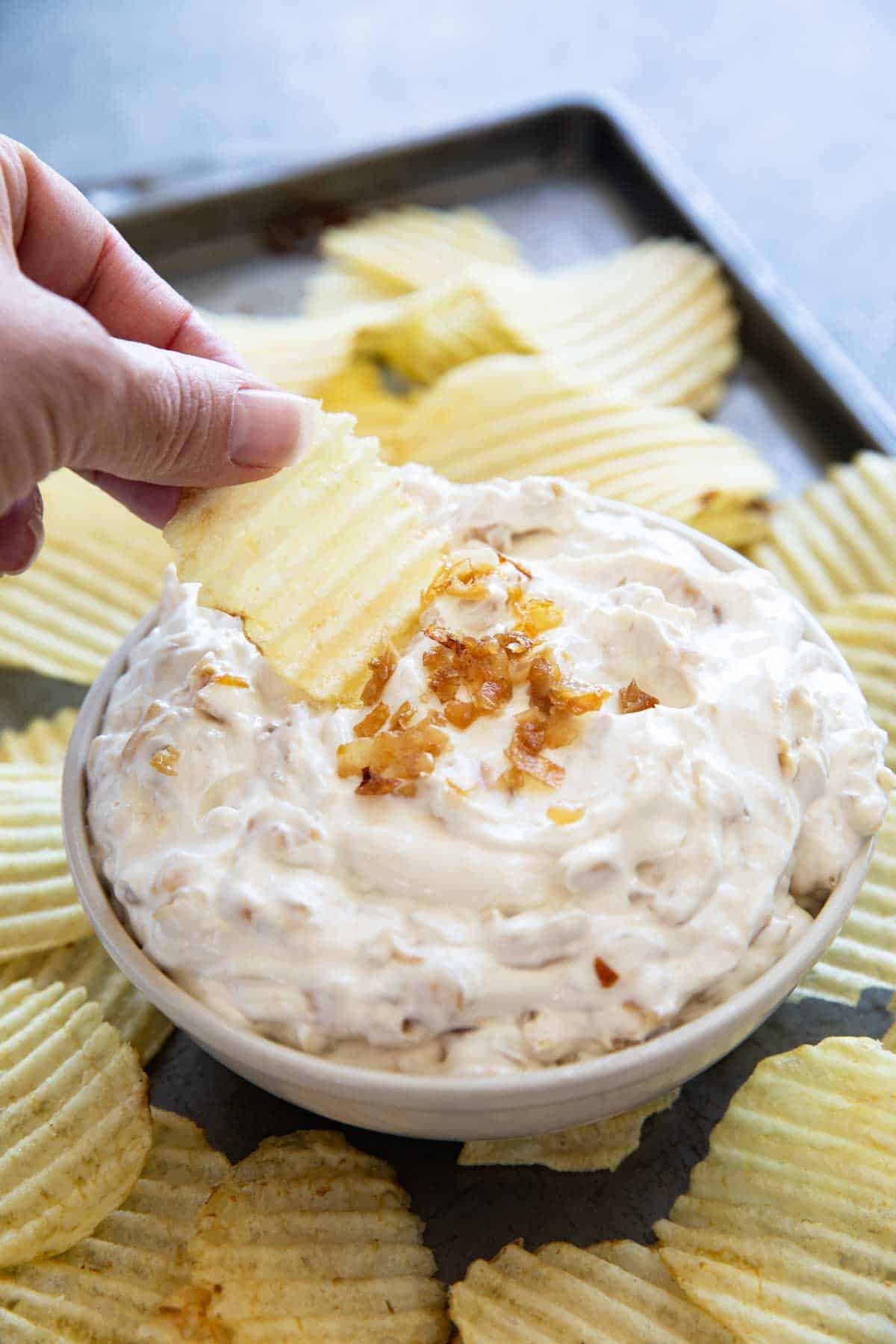 Dipping a potato chip into French Onion Dip.
