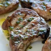 Grilled Pork Chops topped with Cilantro Lime Sauce.