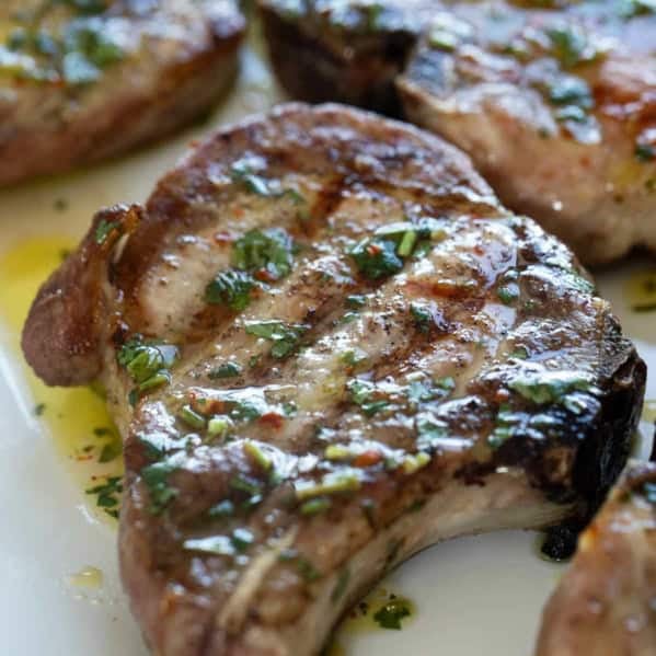 Grilled Pork Chops topped with Cilantro Lime Sauce.