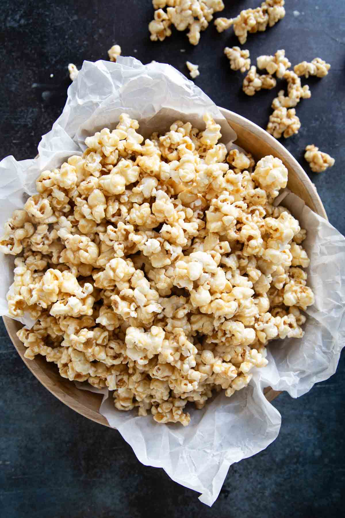 Bowl lined with parchment then filled with soft caramel popcorn.
