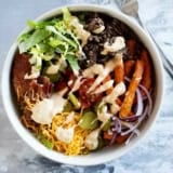 Burger Bowls with beef, sweet potato fries, onions, tomatoes, cheese, bacon, and more.