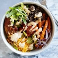 Burger Bowls with beef, sweet potato fries, onions, tomatoes, cheese, bacon, and more.