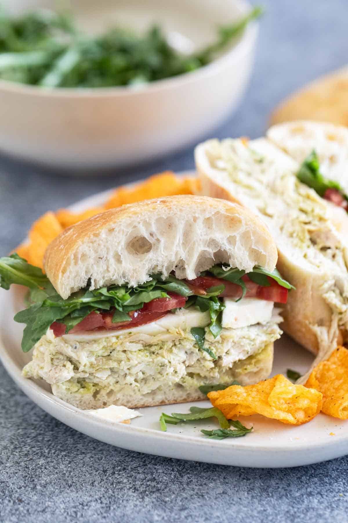 Chicken Pesto Sandwich cut in half on a plate.