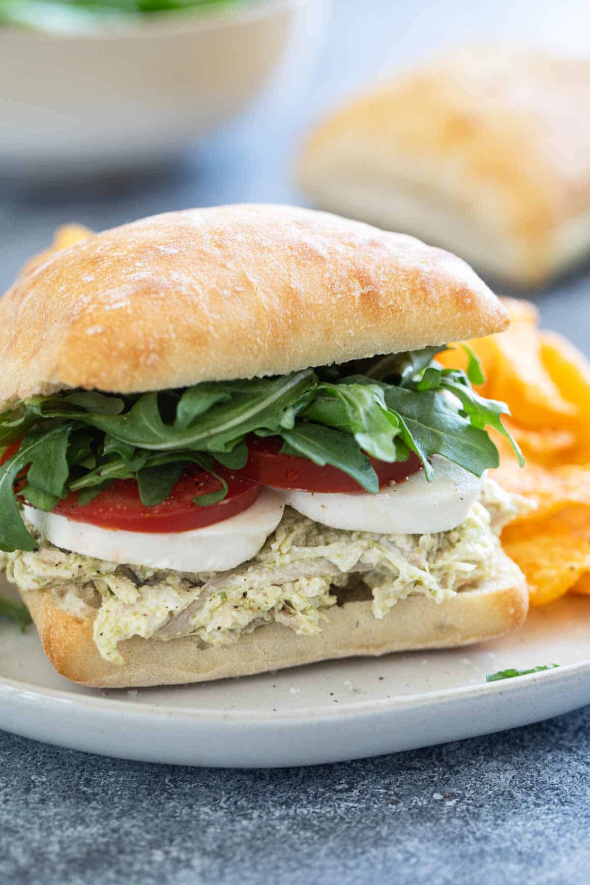 Chicken Pesto Sandwich with tomatoes, mozzarella, and arugula.
