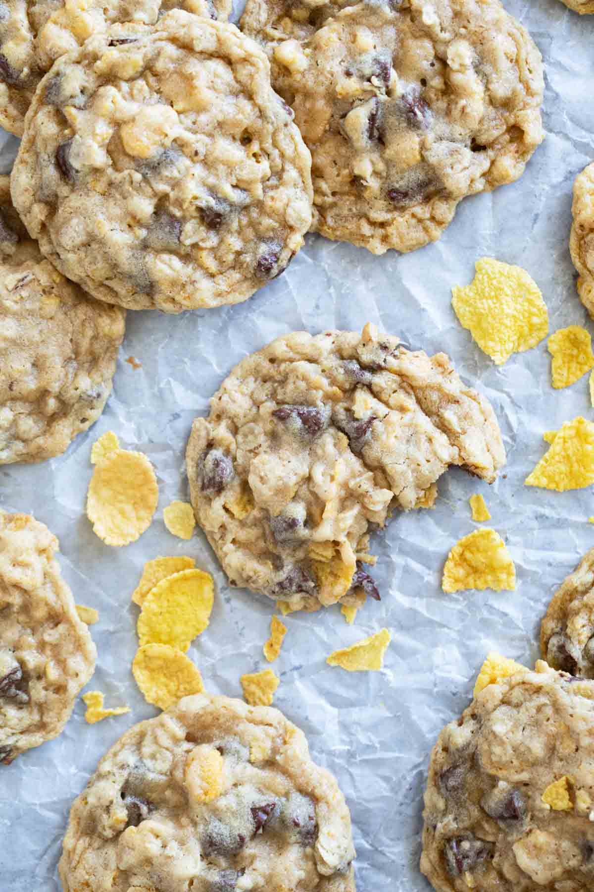 Chocolate chip Cornflake Cookies on parchment paper with a bite taken from one cookie.