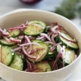 Bowl with Cucumber Onion Salad with fresh dill and salt and pepper.