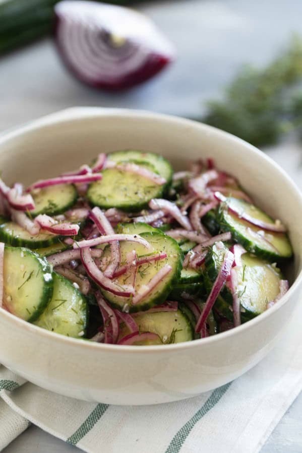 Bowl with Cucumber Onion Salad with fresh dill and salt and pepper.
