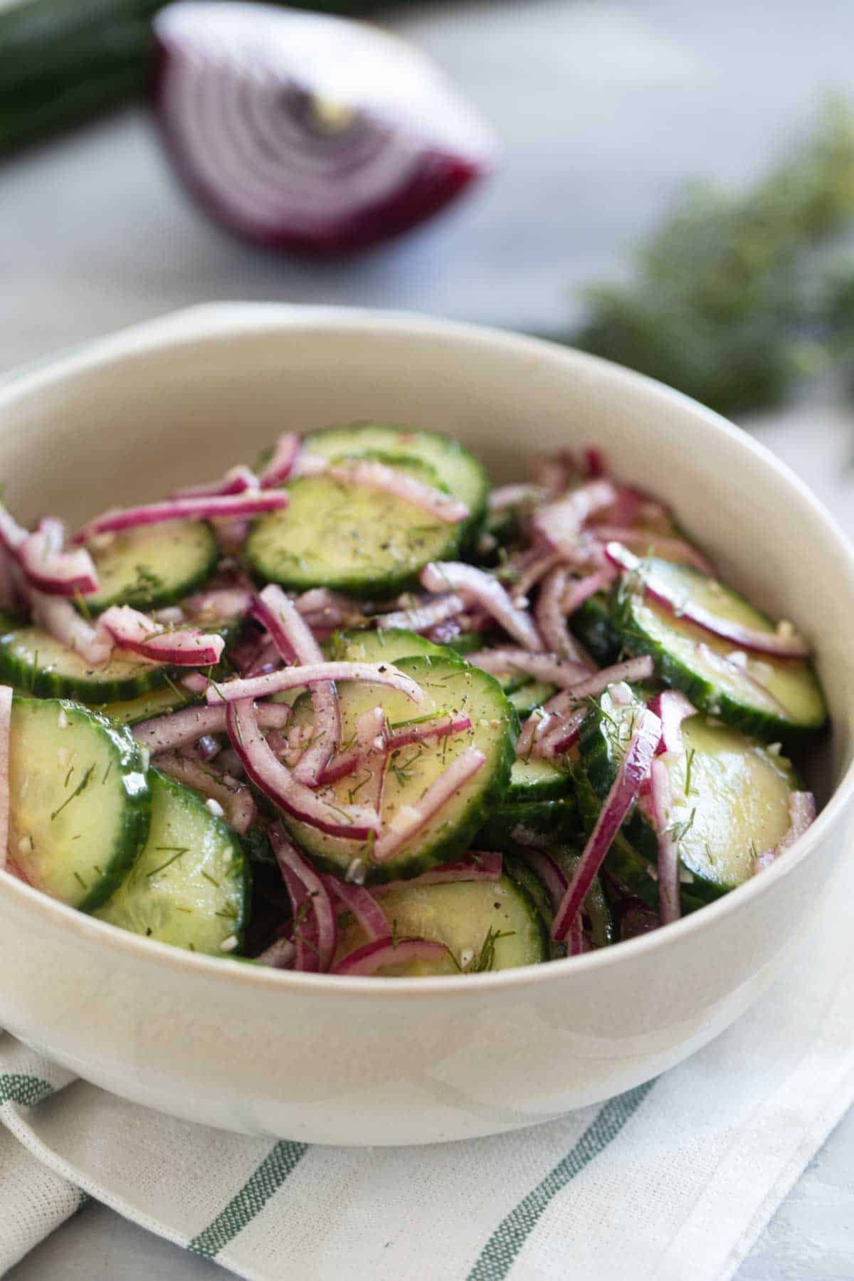 Bowl with Cucumber Onion Salad with fresh dill and salt and pepper.