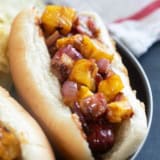 Hawaiian Hot Dogs with grilled pineapple and red onion with barbecue sauce.