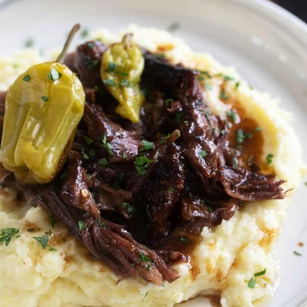 Mississippi Pot Roast over mashed potatoes with pepperoncini peppers.
