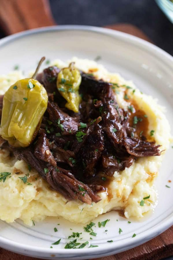 Mississippi Pot Roast over mashed potatoes with pepperoncini peppers.