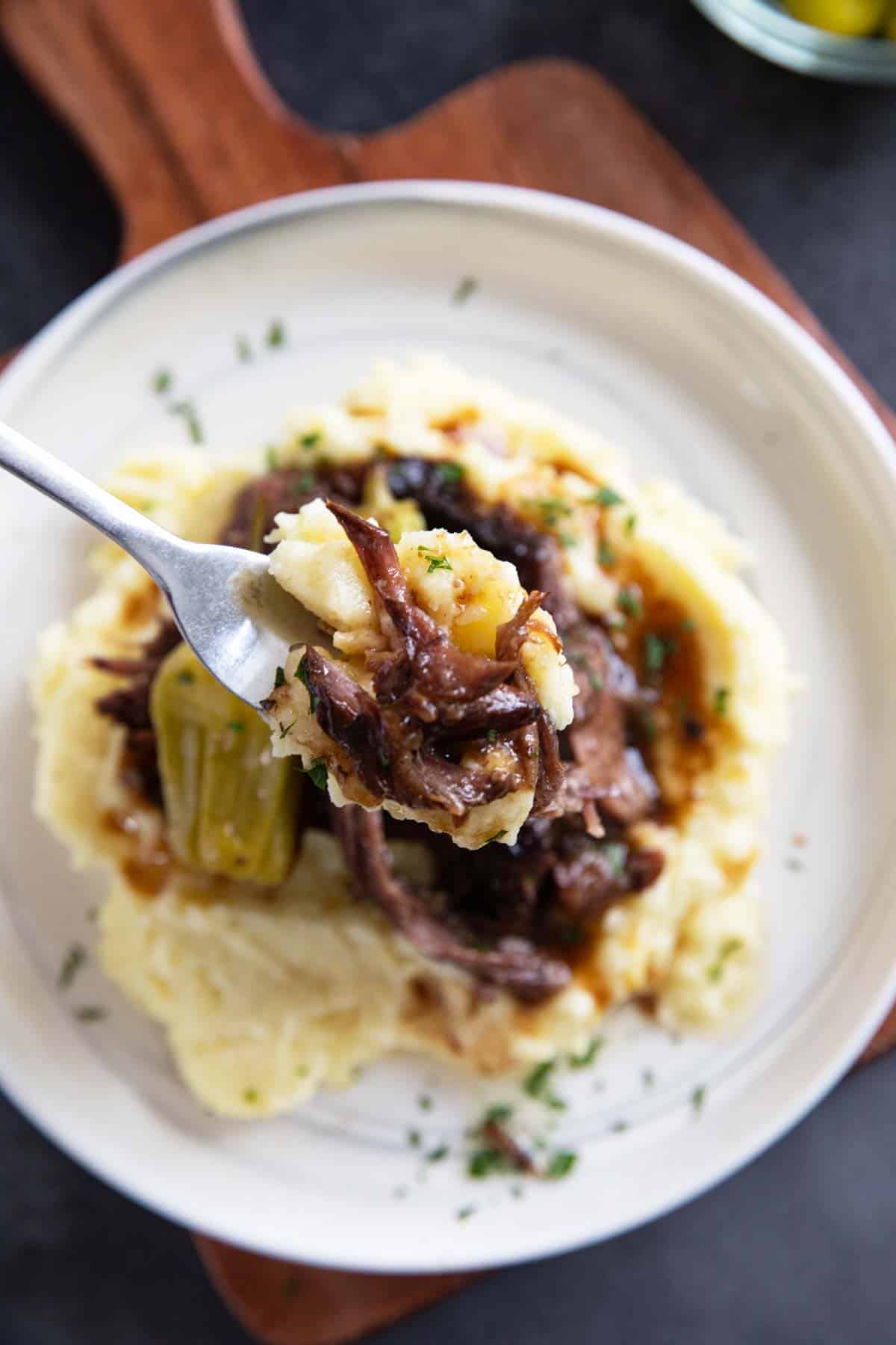 Fork full of Mississippi Pot Roast with mashed potatoes.