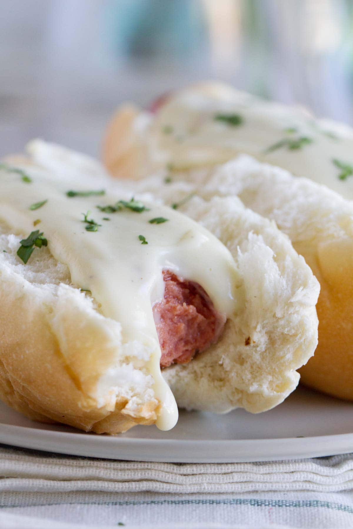 Cordon Bleu Hot Dogs on a plate with a bite take from one.