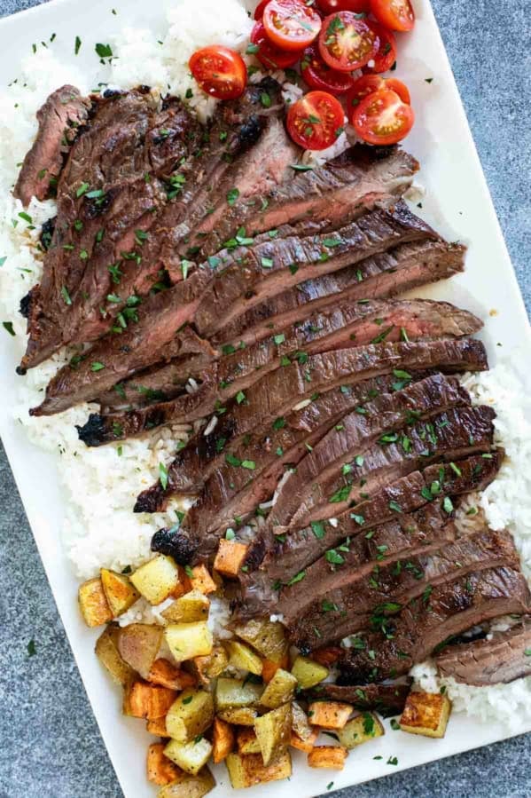 Korean Flank Steak over rice on a serving platter.