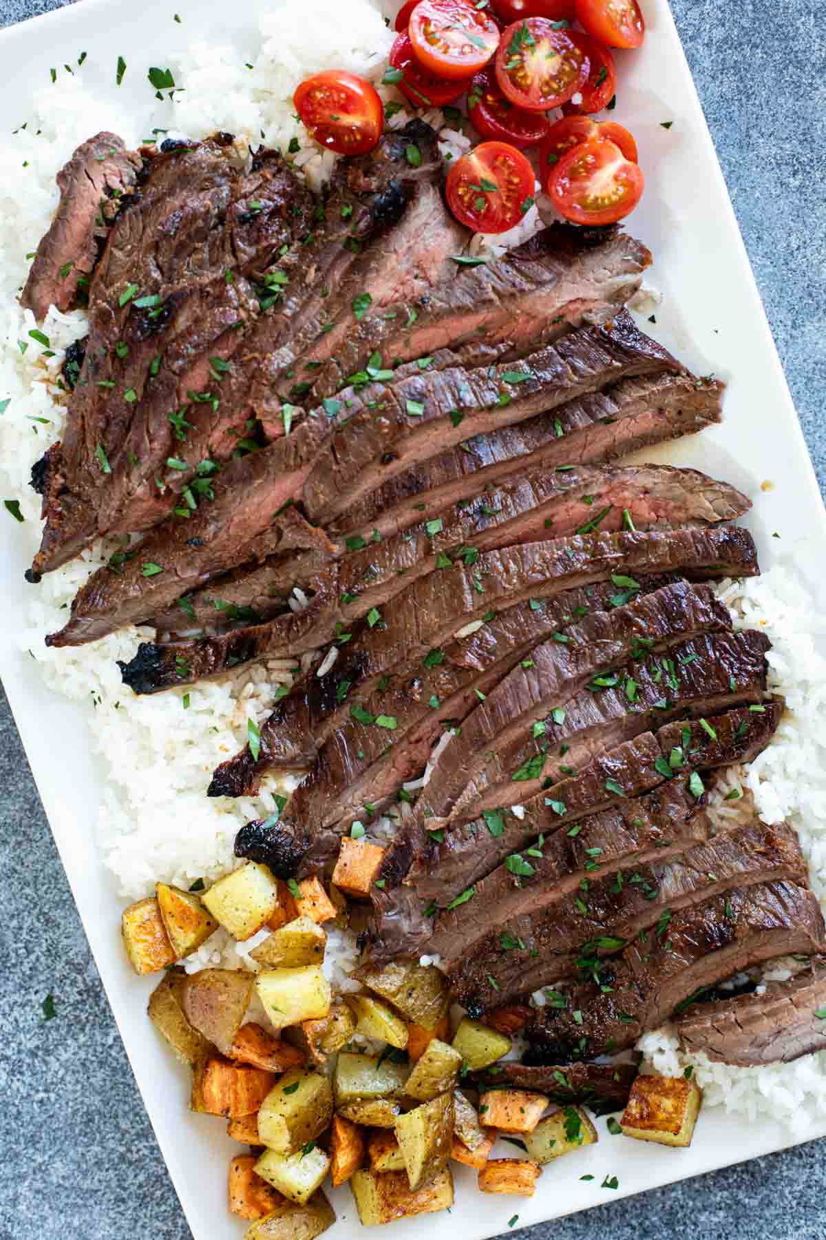 Korean Flank Steak over rice on a serving platter.
