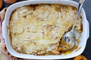 Cooked peach dump cake with a portion taken out.