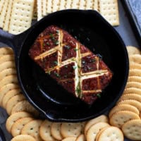 Smoked cream cheese in a cast iron dish, surrounded by crackers.