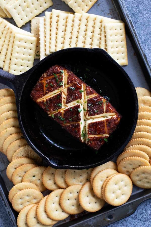 Smoked cream cheese in a cast iron dish, surrounded by crackers.