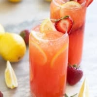 Glasses of strawberry lemonade with real lemon juice and strawberry syrup from scratch.