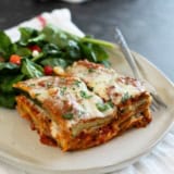 Slice of Zucchini Parmesan on a plate with a salad.