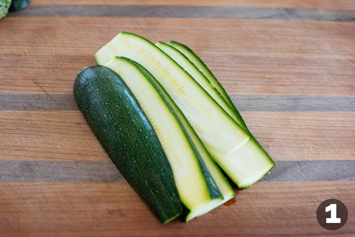 Cutting zucchini into long slices.