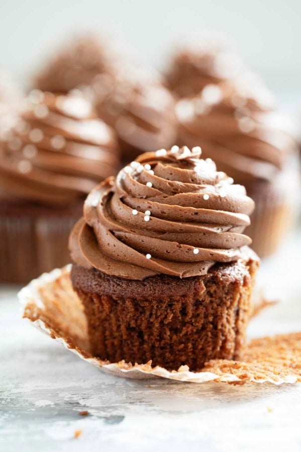 Eggless Chocolate Cupcakes with chocolate frosting with the wrapper pulled back.
