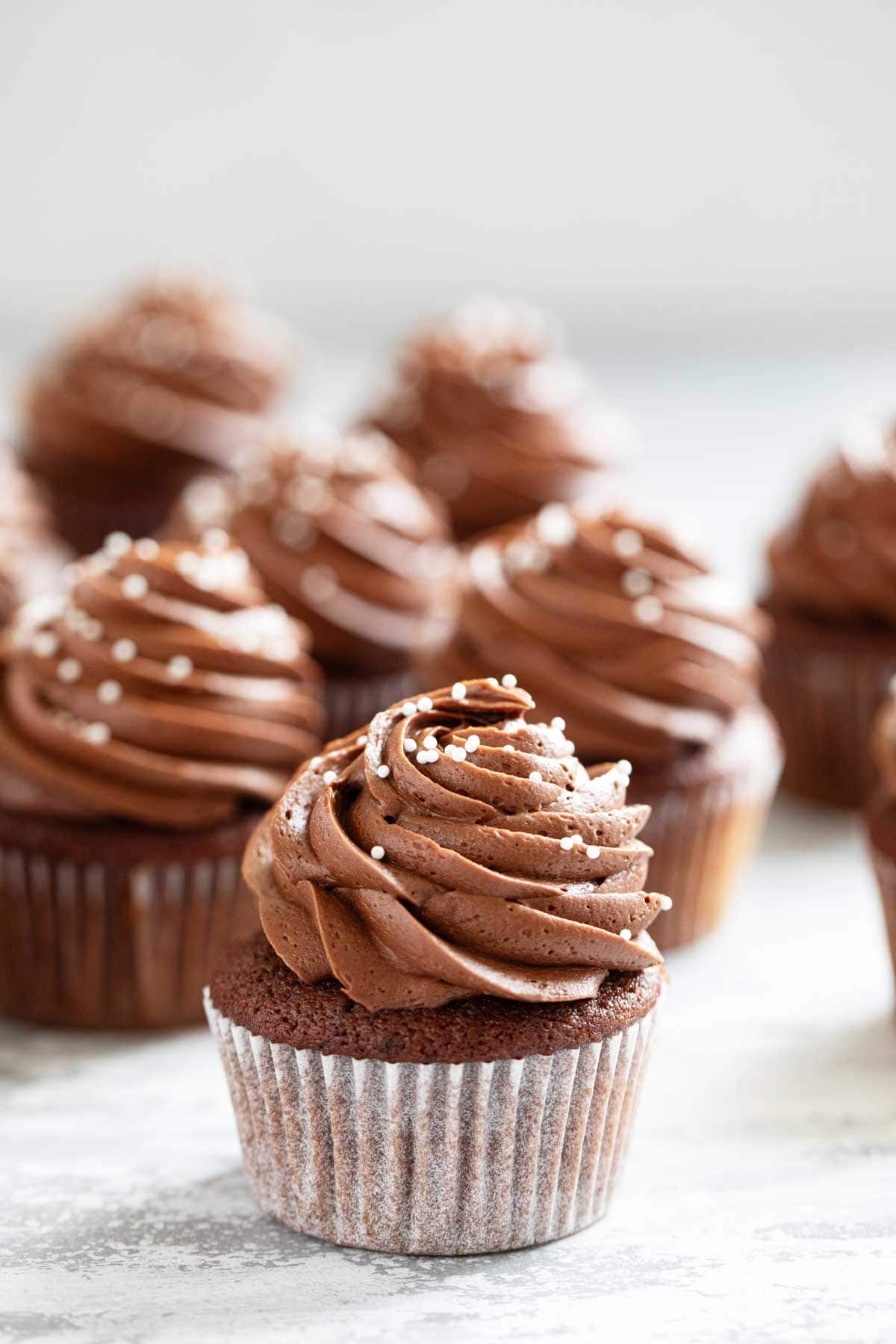 Eggless Chocolate Cupcakes topped with chocolate frosting.