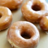 Glazed Donuts on parchment paper.