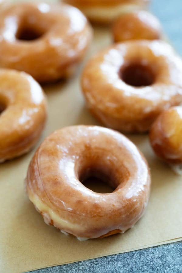 Glazed Donuts on parchment paper.