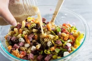 Adding dressing to Italian Pasta Salad.