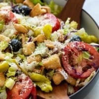 Olive Garden Salad topped with parmesan cheese.