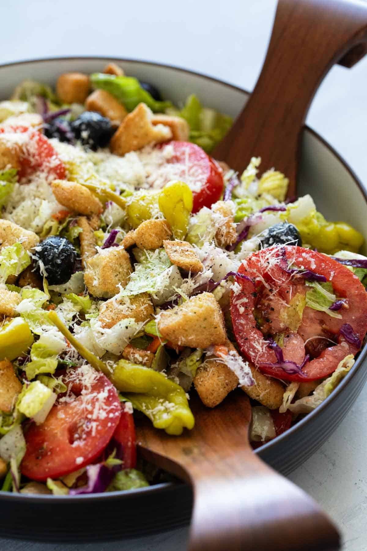 Olive Garden Salad topped with parmesan cheese.