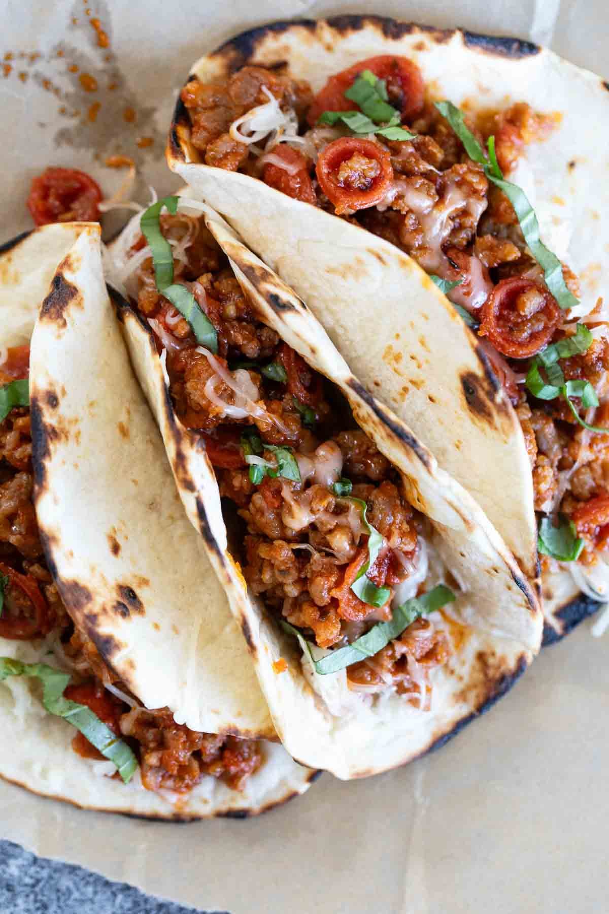 Pizza Tacos with sausage, pepperoni, cheese, and basil.