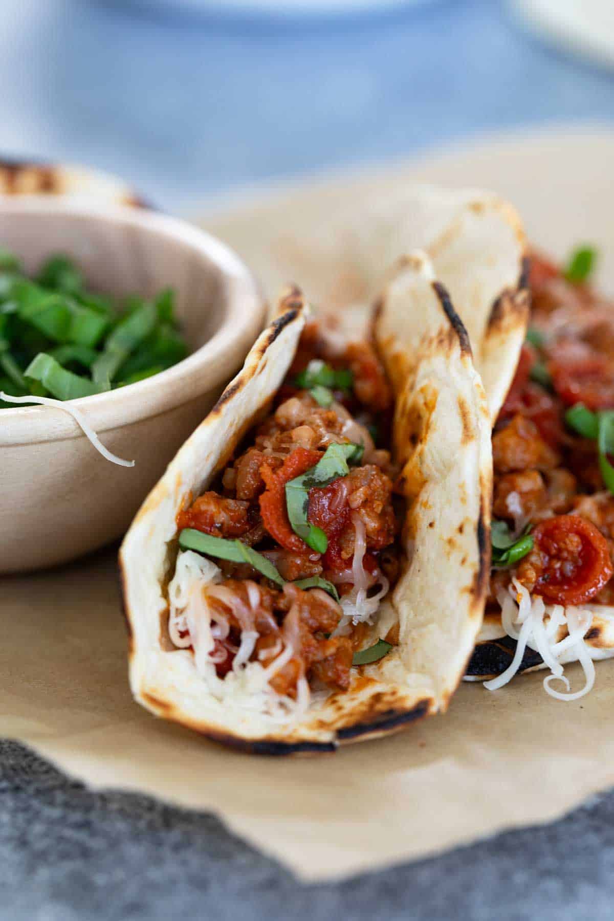 Pizza Tacos with a bowl of fresh basil.