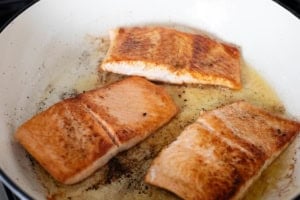 Cooking Tuscan Salmon in a skillet.