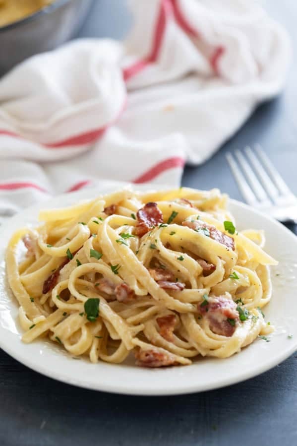 Plate with Brie Pasta with Bacon topped with parsley.
