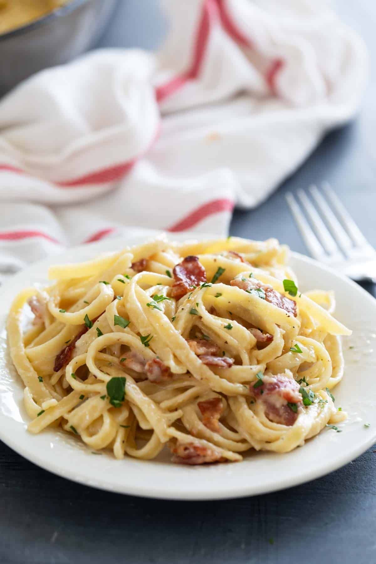 Plate with Brie Pasta with Bacon topped with parsley.