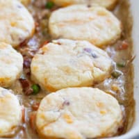 Chicken Pot Pie with Biscuits and Bacon in a white casserole dish.