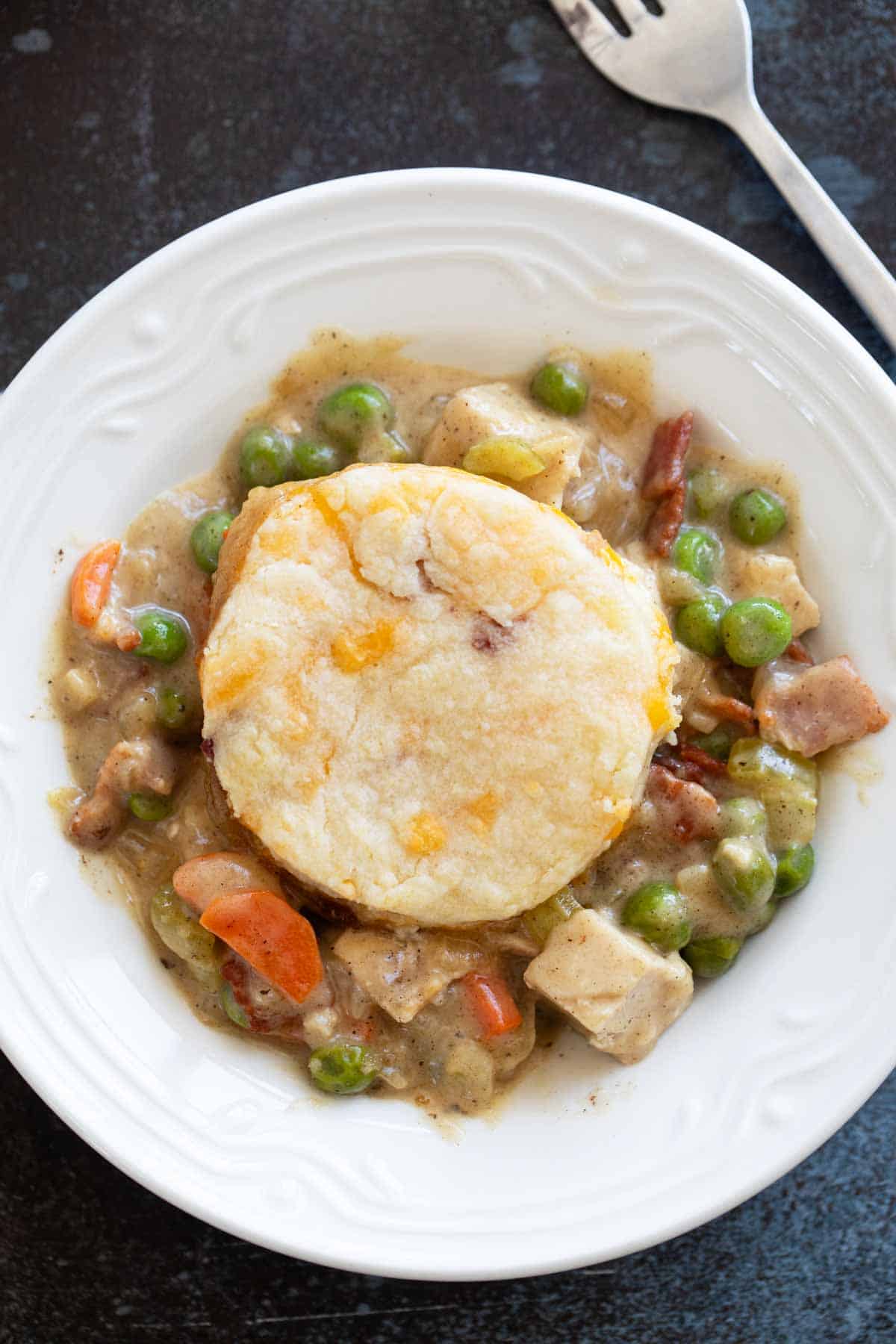 Serving of Chicken Pot Pie with Biscuits and Bacon in a shallow bowl.