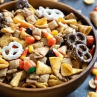 Wooden bowl filled with Halloween Chex mix.